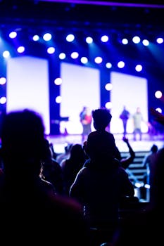 A crowd of people enjoying a live concert with vibrant stage lights.